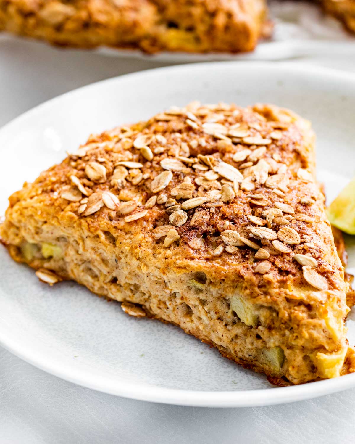 sideview shot of a apple cinnamon scone on a white plate