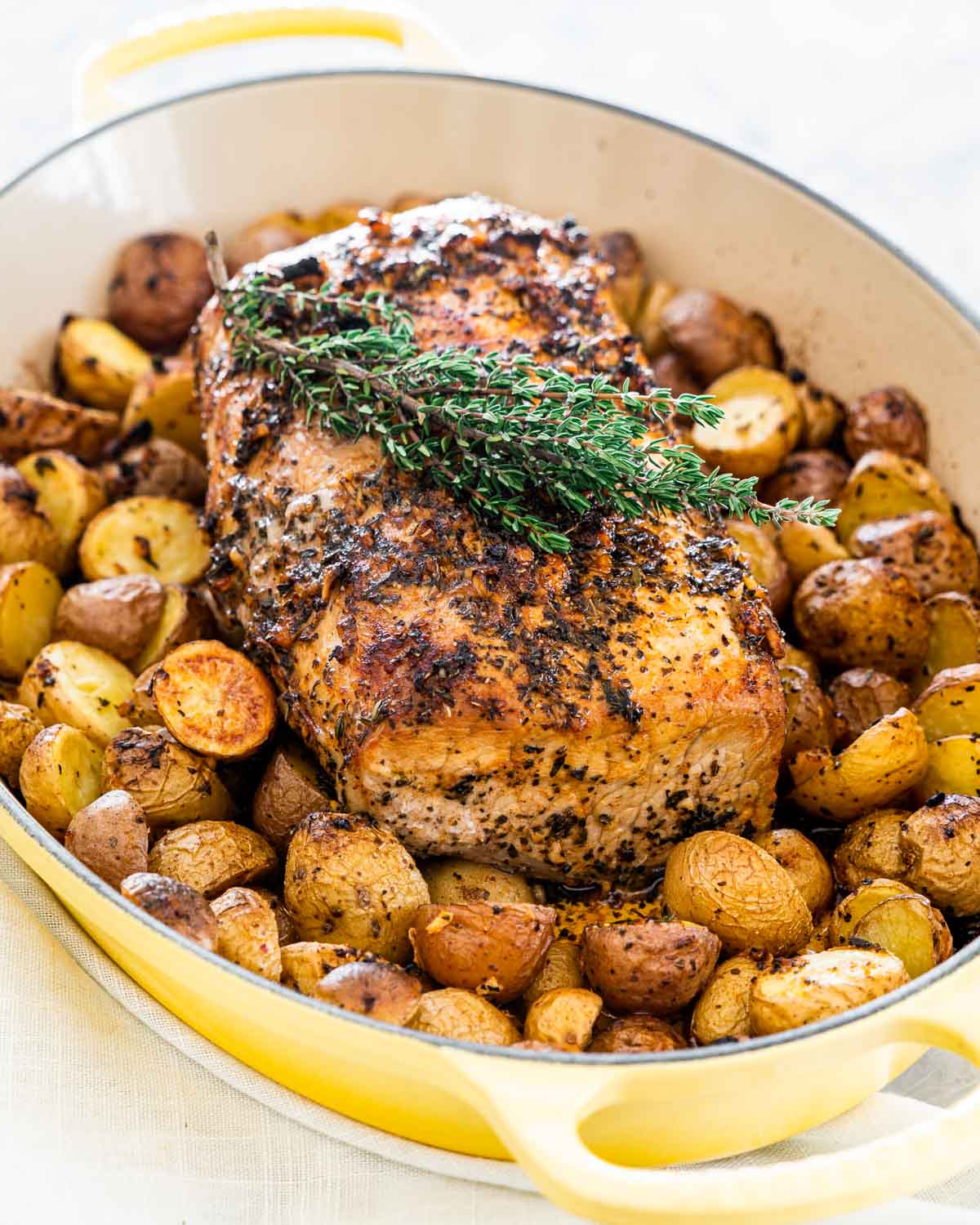 pork roast with roasted potatoes garnished with fresh thyme