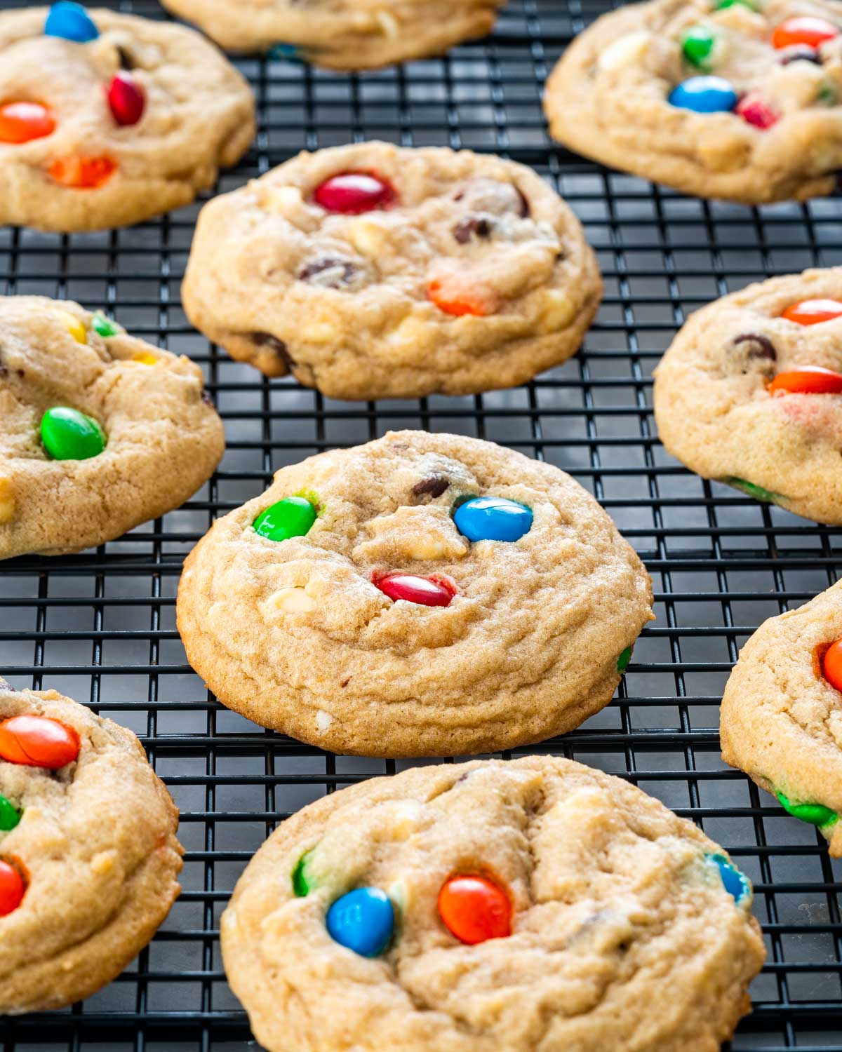 m&m cookies cooling on black cooling rack.