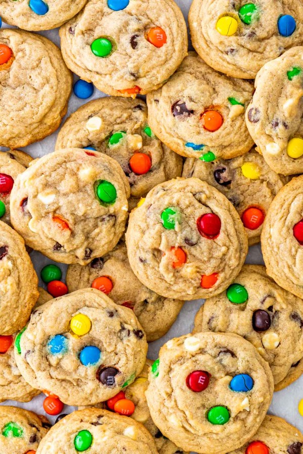 overhead shot of m&m cookies piled together on parchment paper.