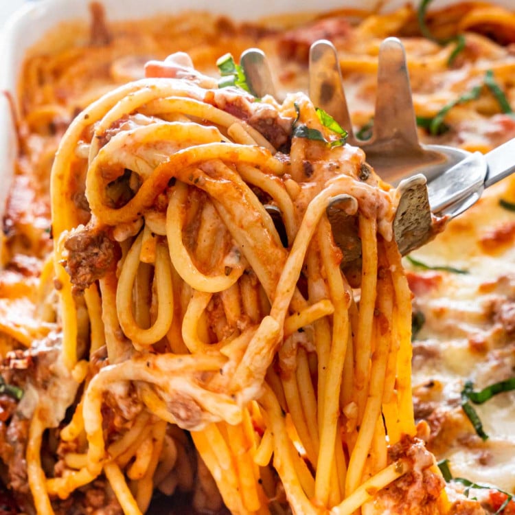 a spaghetti spoon taking a scoop of baked spaghetti casserole