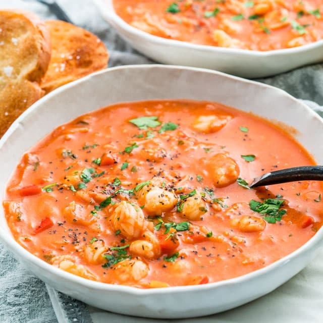 a white bowl loaded with Brazilian Shrimp Soup with a spoon inside