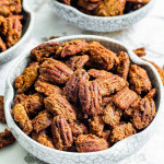 closeup of sugar pecans in a white bowl.