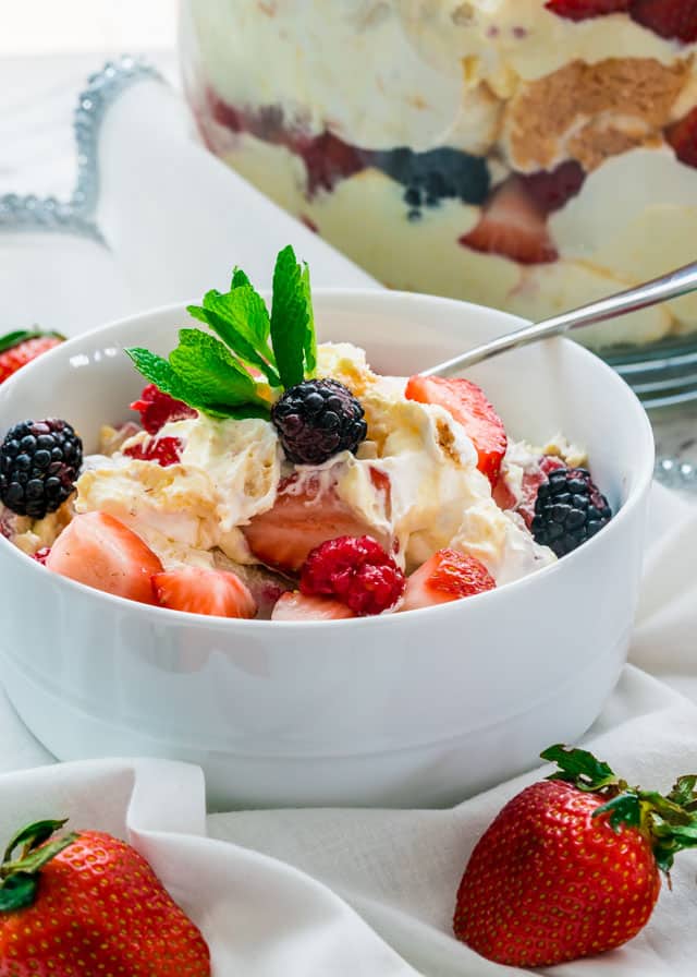 serving of Angel Berry Trifle in a bowl surrounded by a couple strawberries