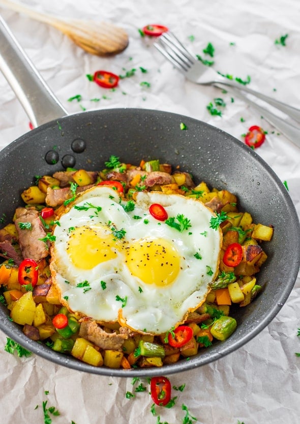 Asparagus Potato Hash with Steak and Eggs in a skillet 