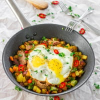 asparagus potato hash with steak and eggs in a skillet