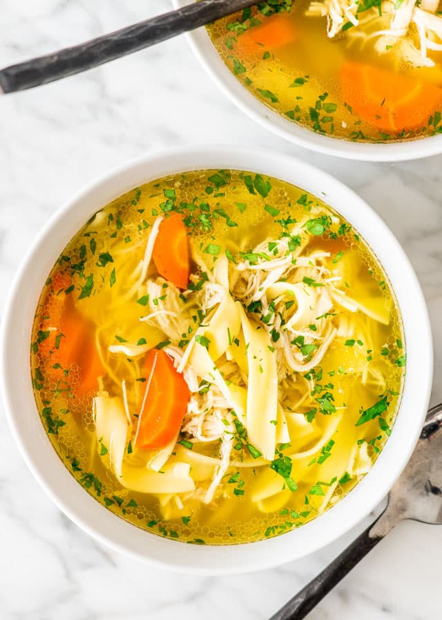two white bowls with Crockpot Chicken Noodle Soup