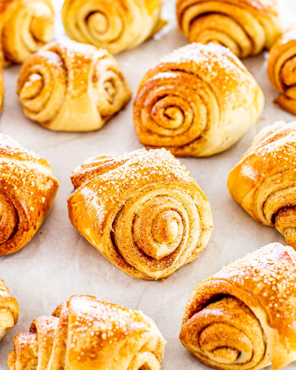 a bunch of finnish cardamom rolls on parchment paper