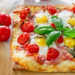 freshly baked breakfast pizza with pancetta, gruyere, tomatoes and eggs