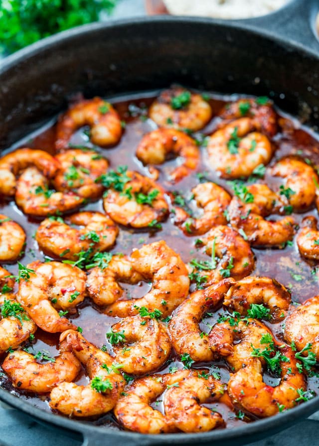 Spicy New Orleans Shrimp in a skillet right out of the oven garnished with parsley
