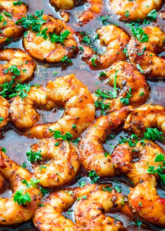 Spicy New Orleans Shrimp in a skillet garnished with parsley