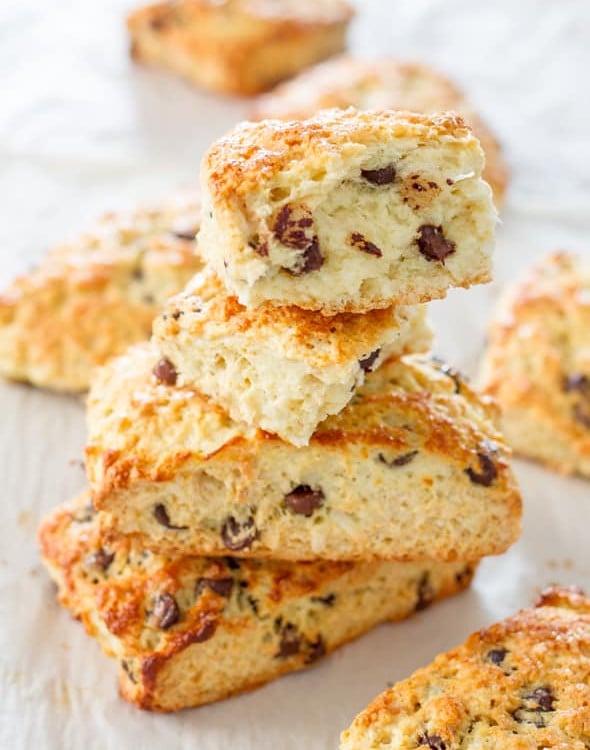 a stack of chocolate chip coconut almond scones with a bite taken out of one
