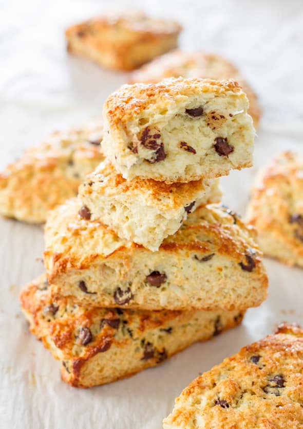 a stack of chocolate chip coconut almond scones with a bite taken out of one