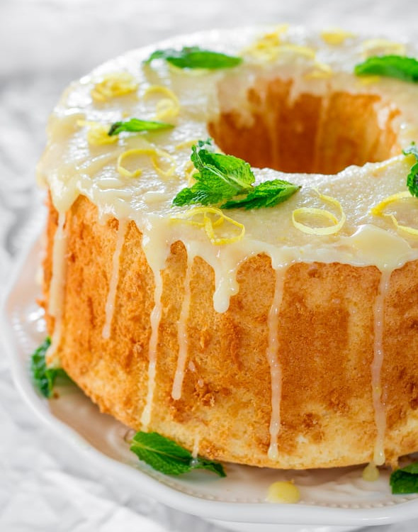a lemon chiffon cake garnished with mint leaves and lemon zest