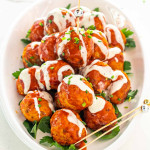 a plate with crockpot buffalo chicken meatballs drizzled with blue cheese dressing.