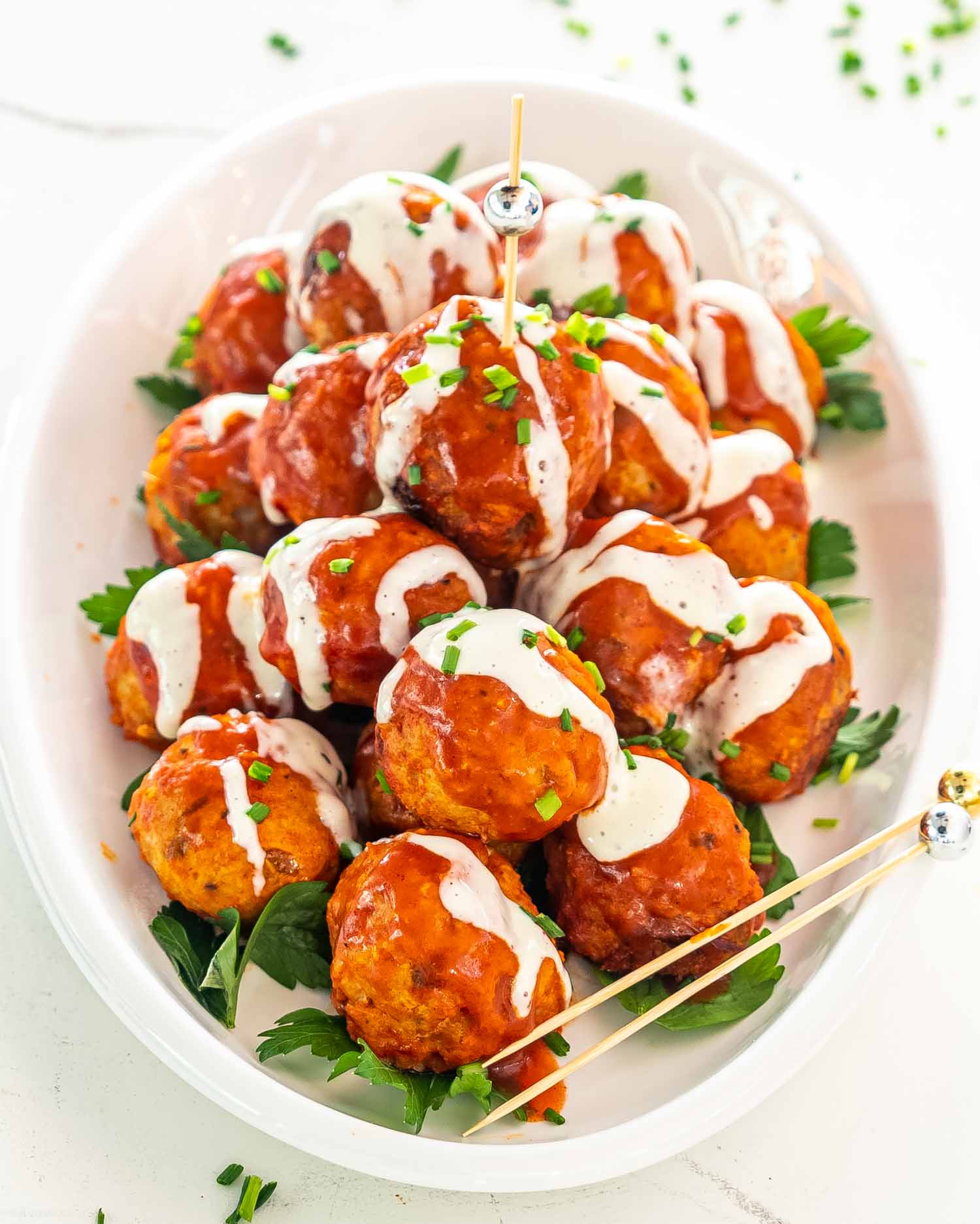 a plate with crockpot buffalo chicken meatballs drizzled with blue cheese dressing.