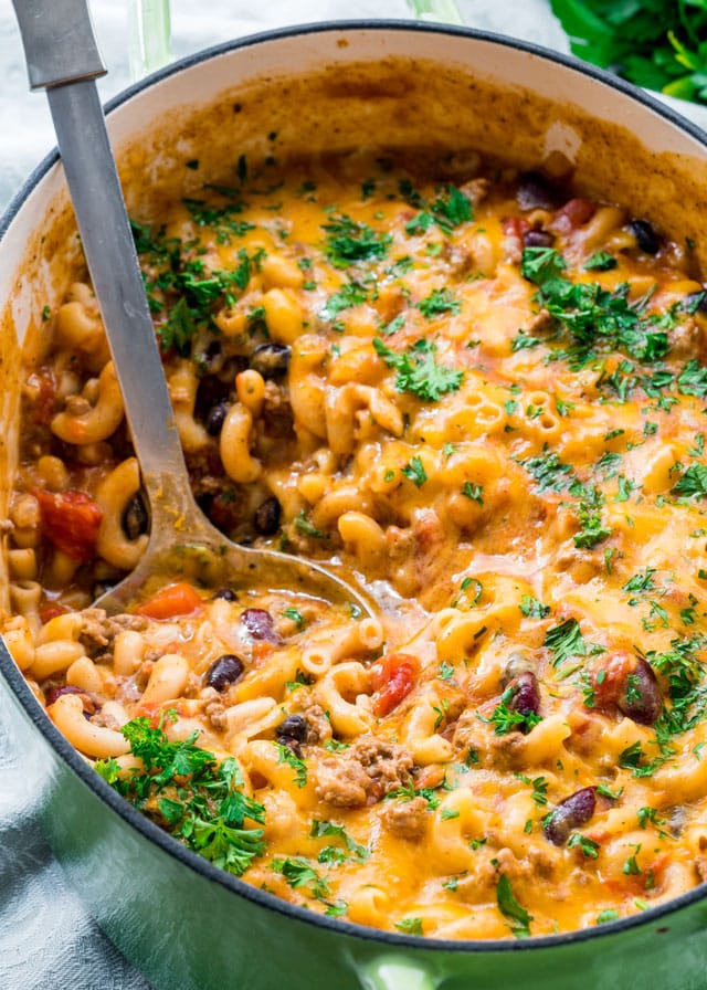 chili mac and cheese in a large pot with a spoon