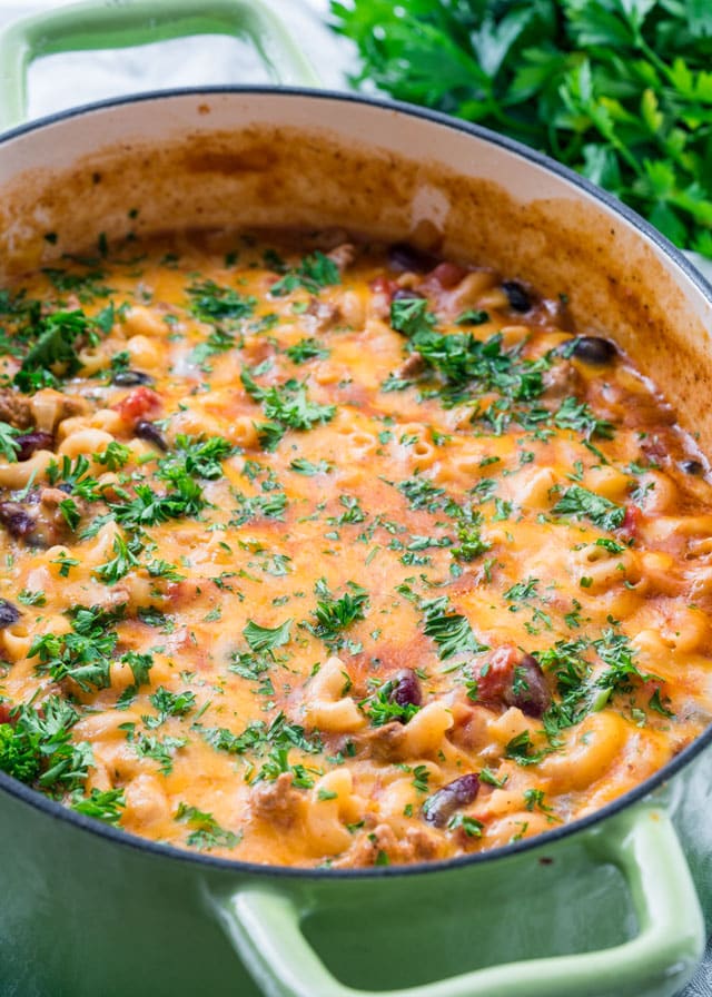 chili mac and cheese in a large pot with parsley in the background