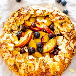 sideview shot of a beautiful peach galette fresh out of the oven with toasted almonds