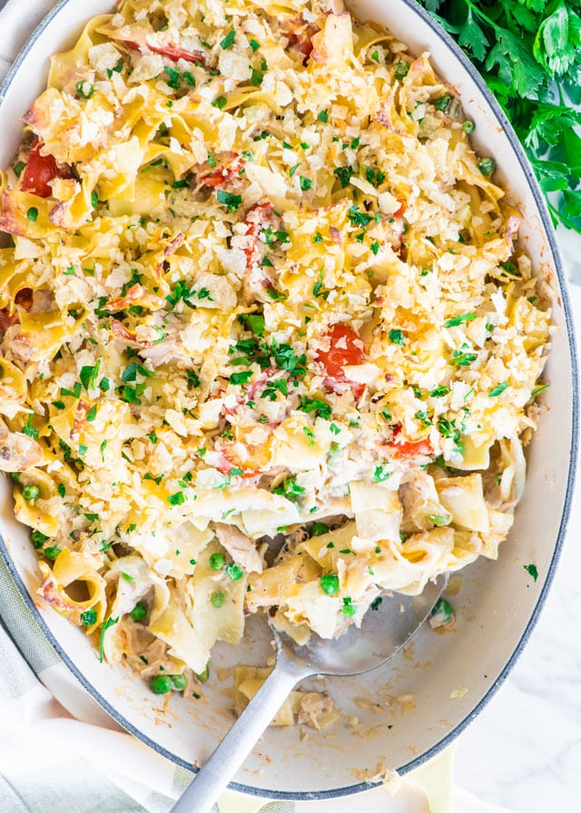 overhead shot of tuna noodle casserole with a serving spoon taking a scoop