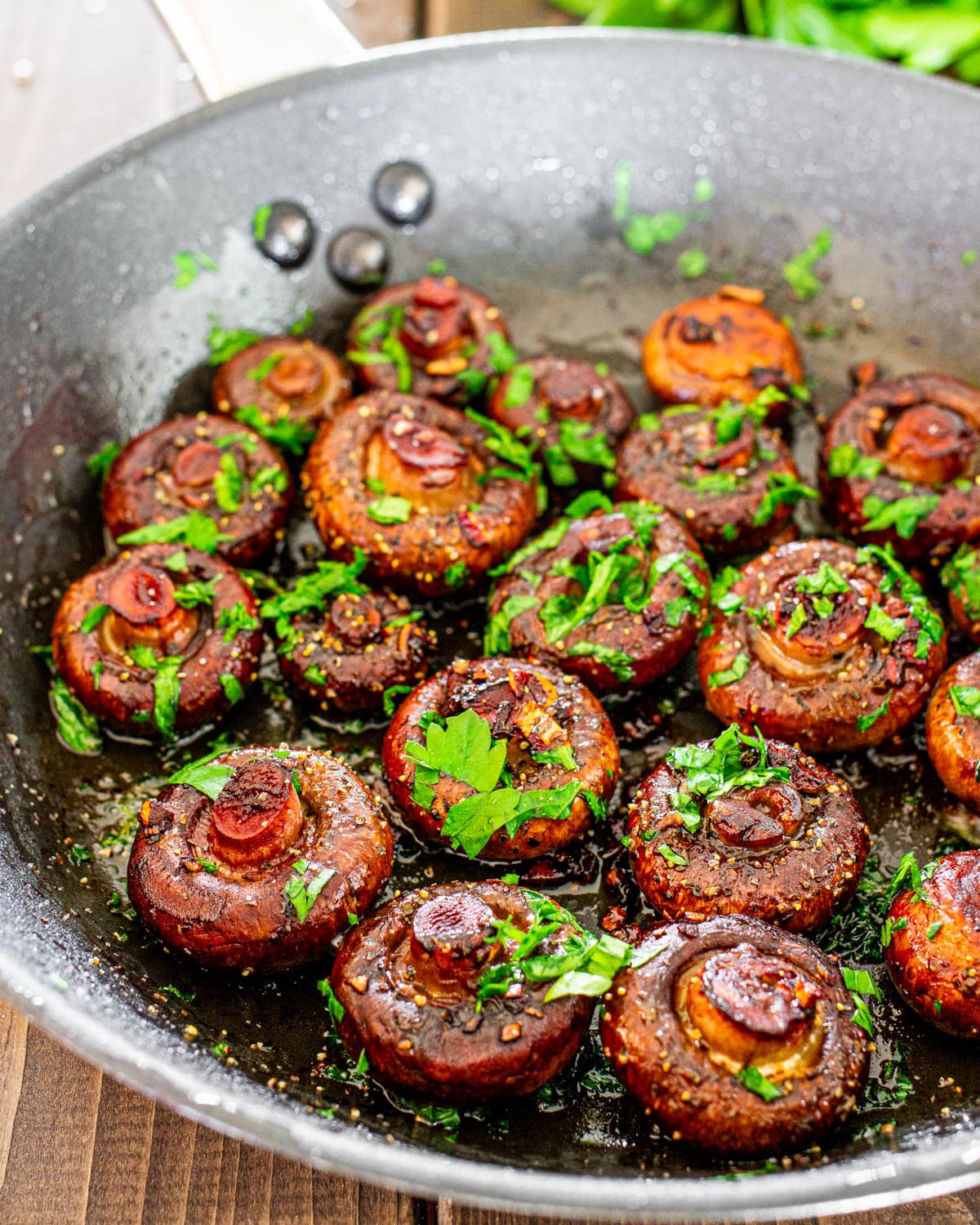 red wine mushrooms in a skillet garnished with parsley