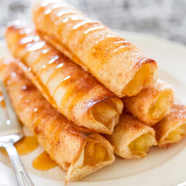 a stack of 6 apple pie taquitos drizzled with caramel sauce