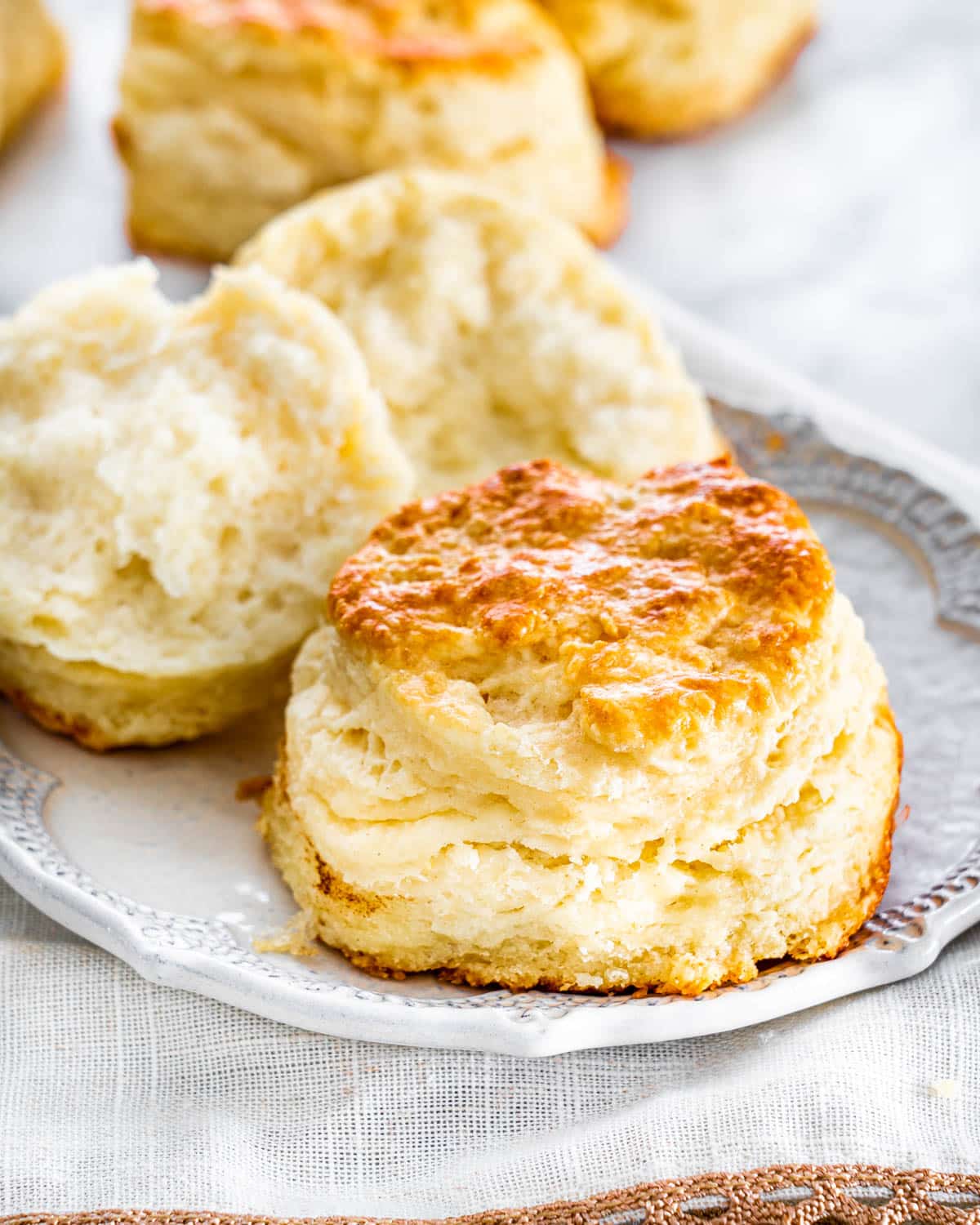 a couple biscuits on a plate with one opened in half