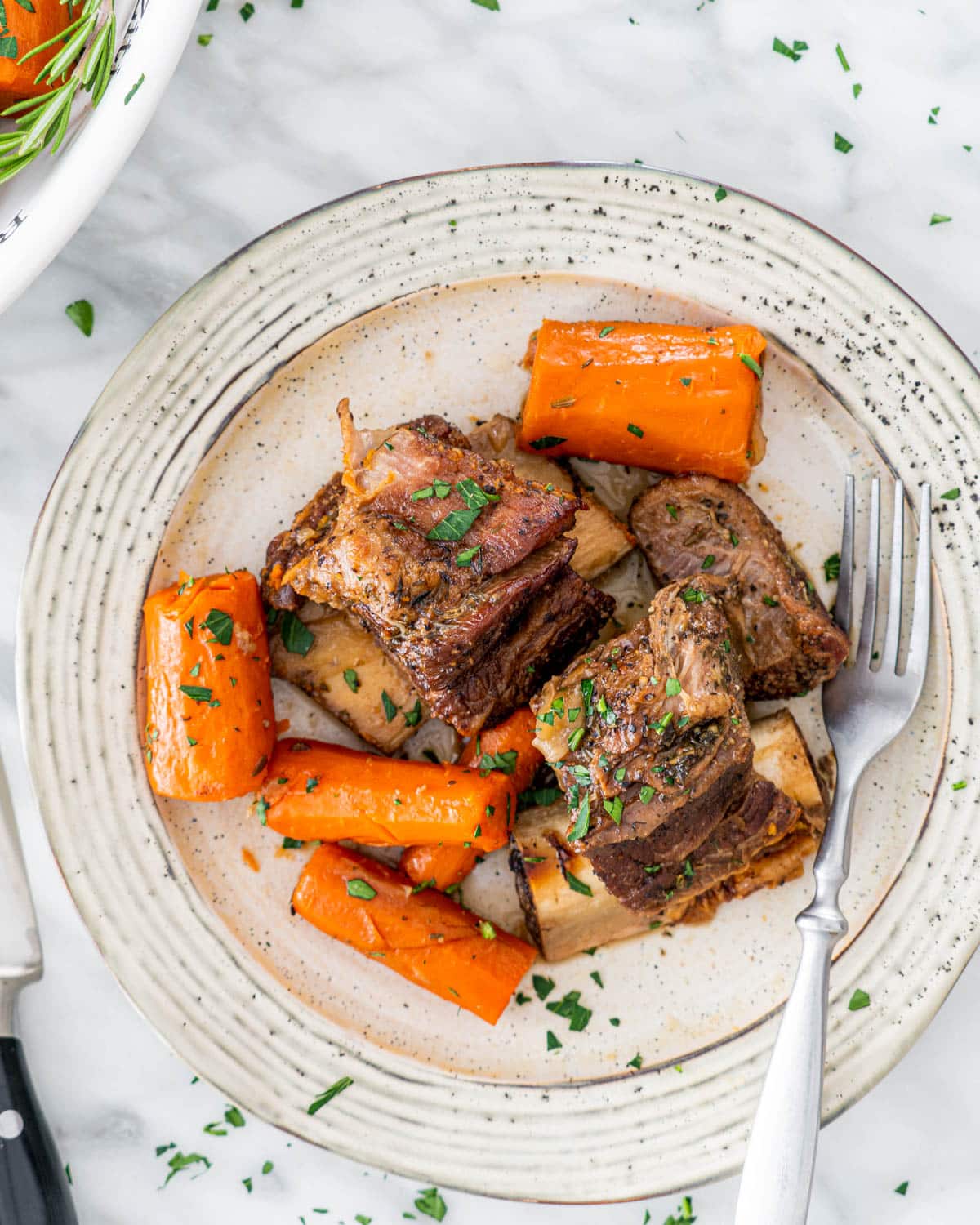 overhead shot of short ribs in a plate with carrots