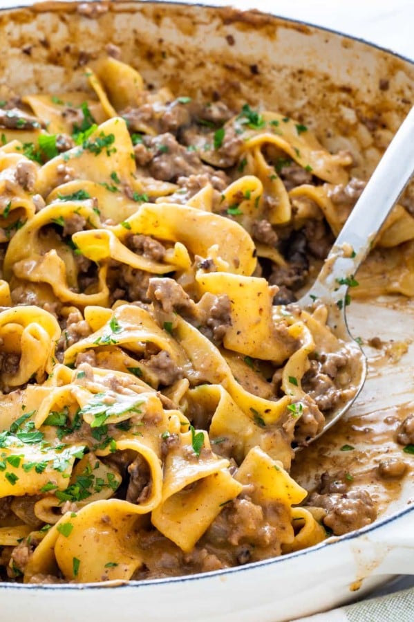 side view shot of a serving spoon taking a scoop of beef stroganoff