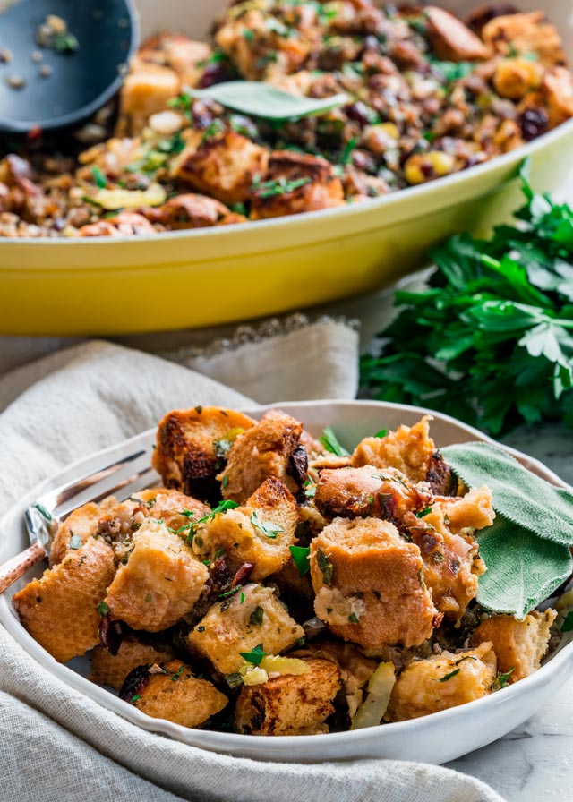 Sage Sausage Stuffing in a plate with a casserole dish in the background