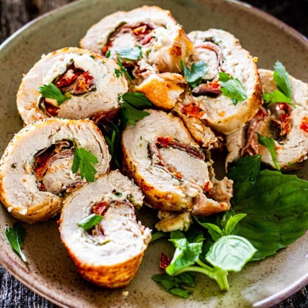 stuffed chicken breast sliced on a plate with basil