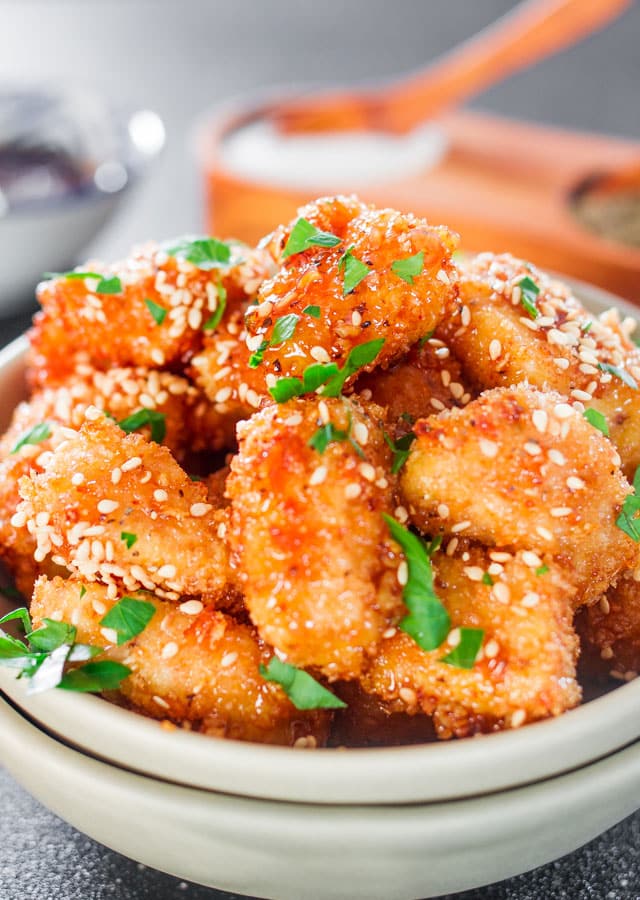 Baked Honey Garlic Chicken in a bowl garnished with sesame seeds and parsley