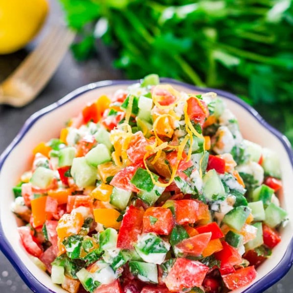 a bowl full of israeli salad with goat cheese