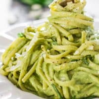 a fork twirling noodles in a bowl of avocado spinach pasta