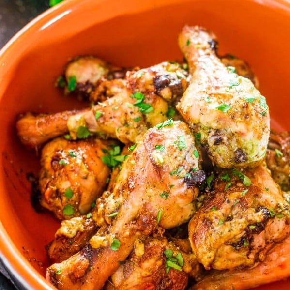 a bowl full of baked garlic and ginger chicken drumsticks
