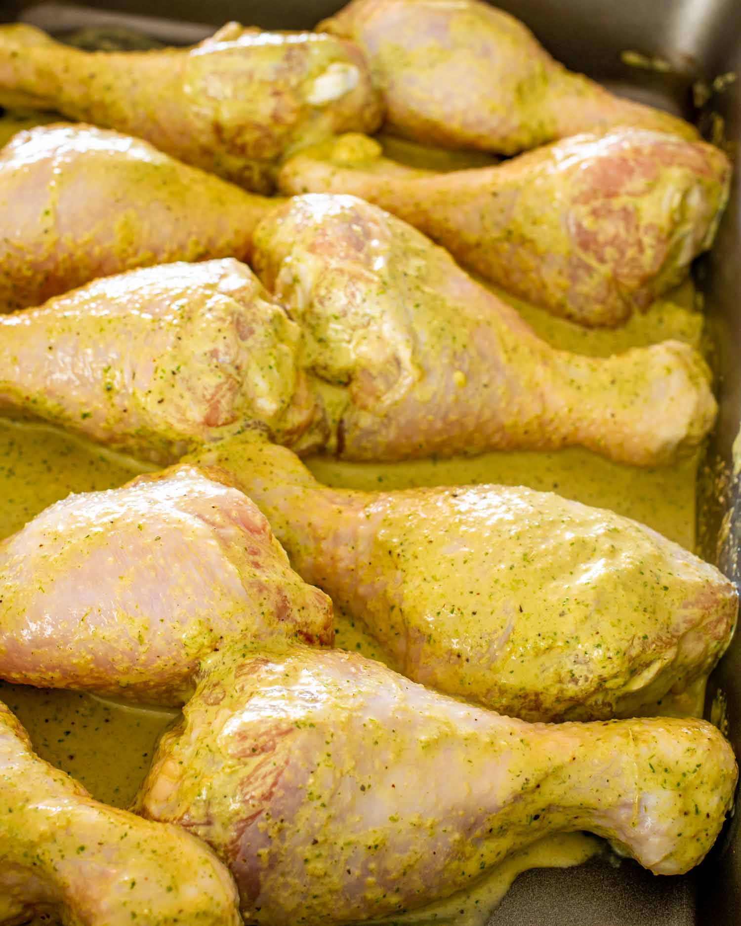 marinated garlic and ginger chicken drumsticks in a baking dish ready to go in the oven.