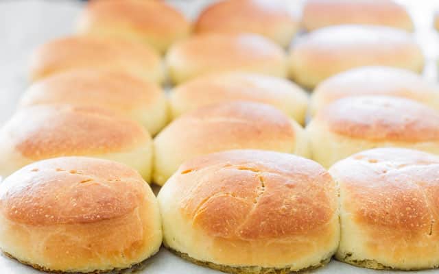 freshly baked slider buns on a baking sheet