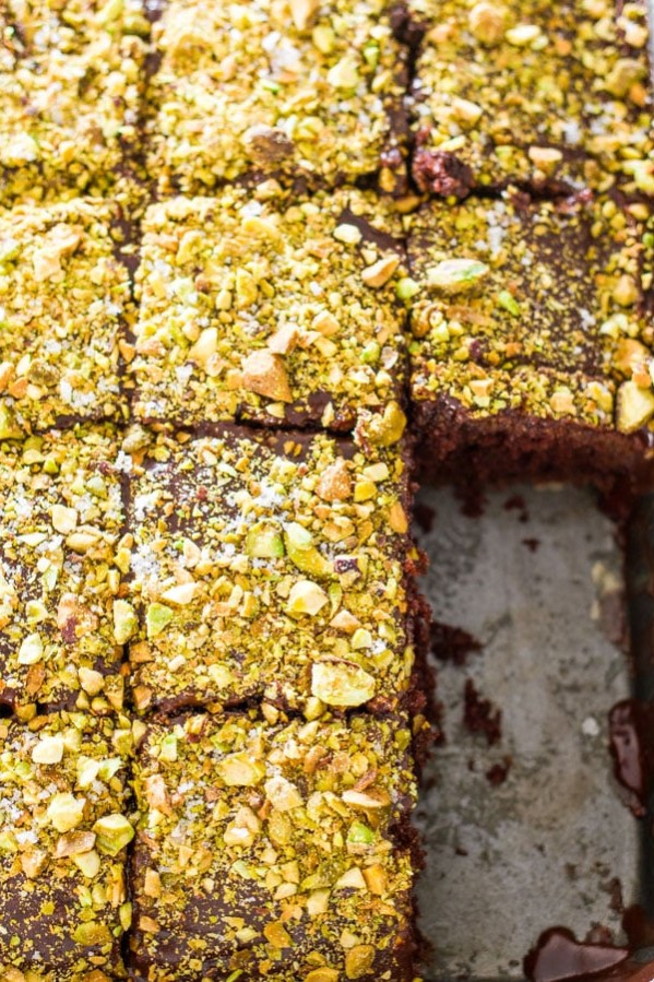salted chocolate texas sheet cake topped with pistachios. A few slices are missing from the pan
