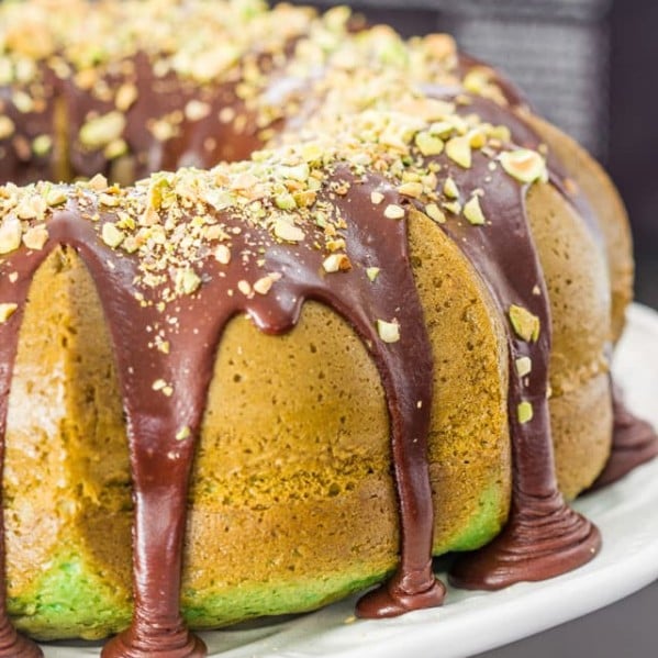 pistachio bundt cake topped with chocolate ganache and chopped pistachios