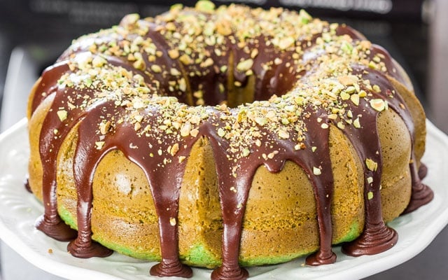 Pistachio Bundt Cake with Chocolate Ganache, topped with pistachios. 
