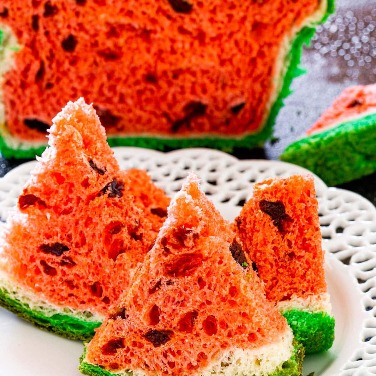 3 wedges of watermelon look-alike bread on a white bread with the bread in the background