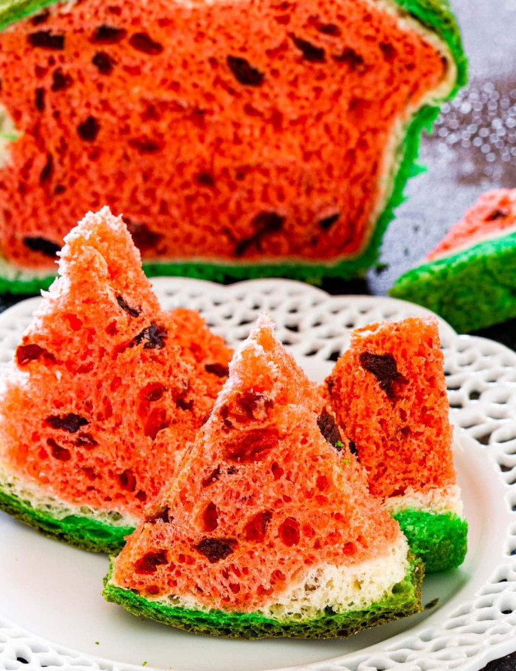 3 wedges of watermelon look-alike bread on a white bread with the bread in the background