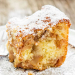 a slice of apple pie cake dusted with powdered sugar on a plate