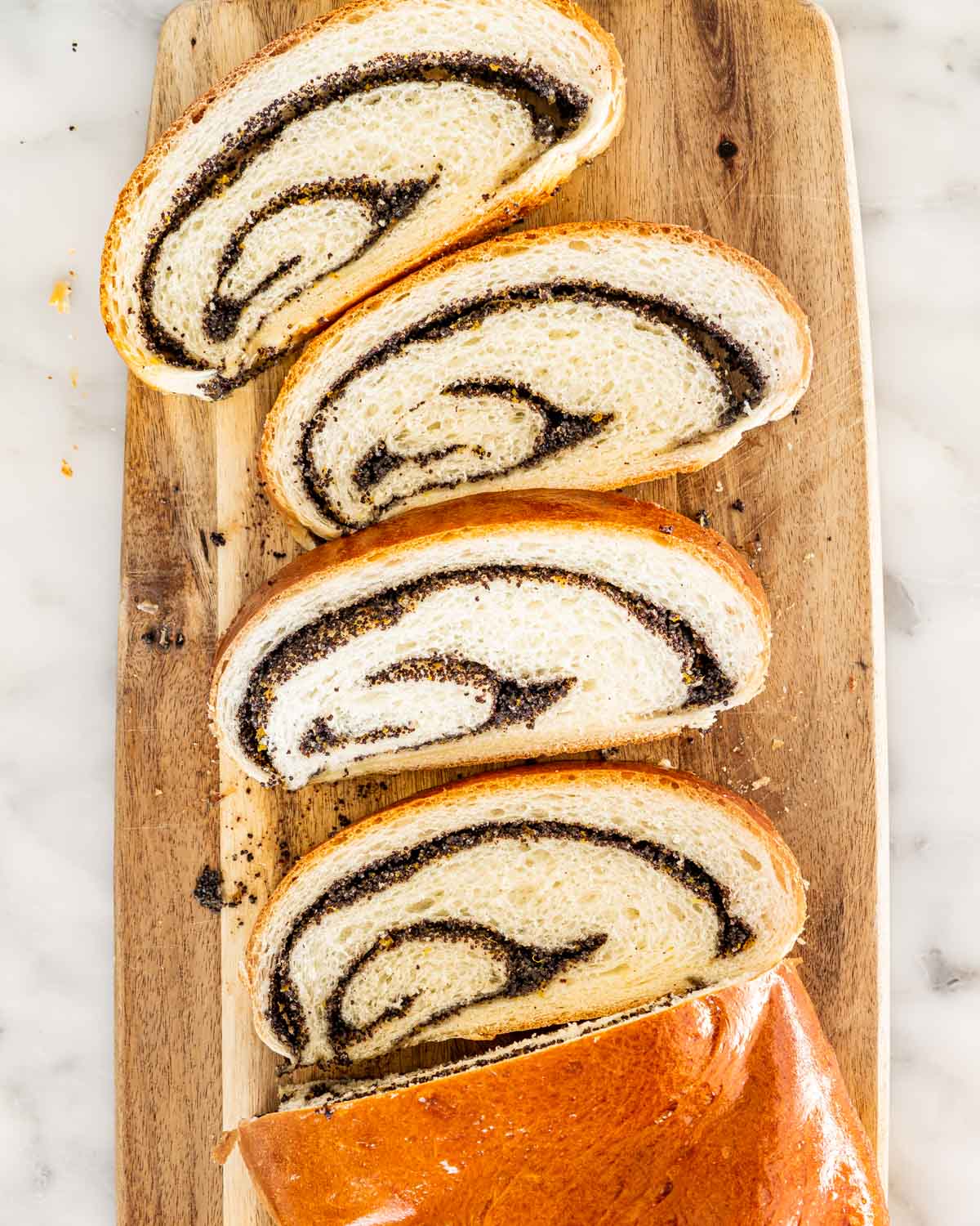 overhead shot of sliced of poppy seed roll on a cutting board