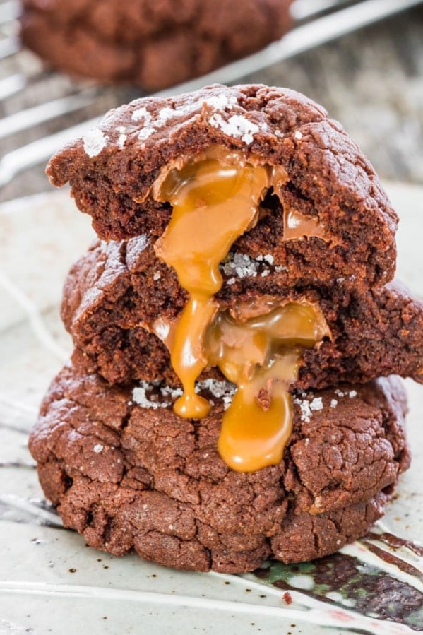 the inside of a split cookie is dripping down a stack of salted rolo and nutella double chocolate cookies.