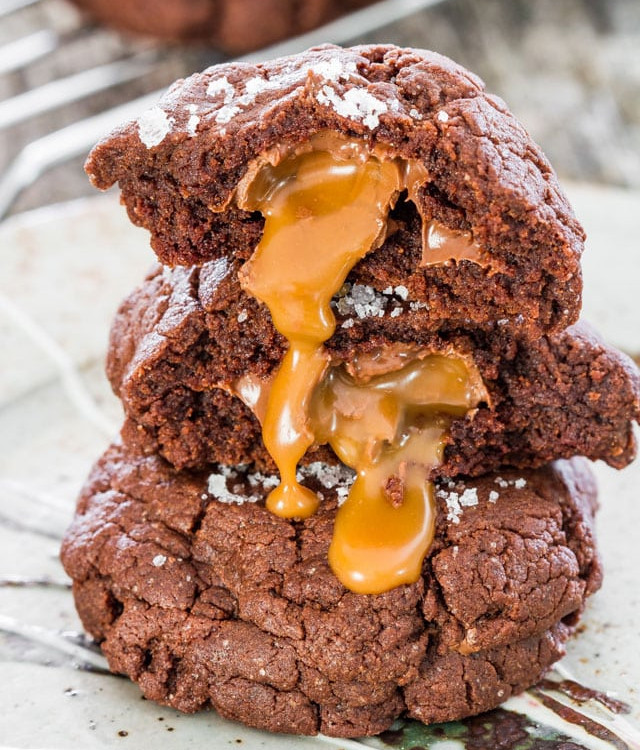 the inside of a split cookie is dripping down a stack of salted rolo and nutella double chocolate cookies.
