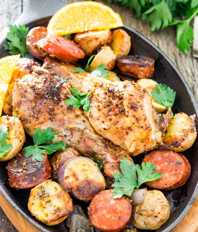 a skillet full of spanish chicken with chorizo and potatoes