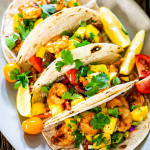 overhead shot of a plate full of cajun shrimp tacos with mango salsa