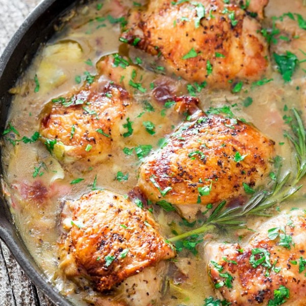 chicken with artichoke and pancetta pan sauce in a skillet