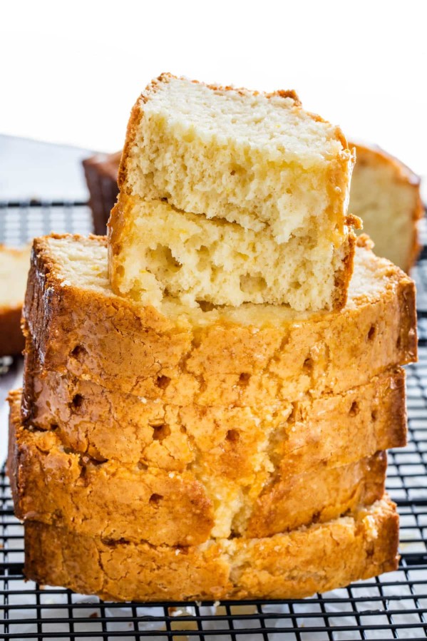 a stack of sliced lemon bread, the top piece has bites taken from it